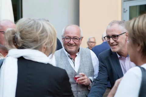 Eine Gruppe von Leuten steht herum und unterhält sich.