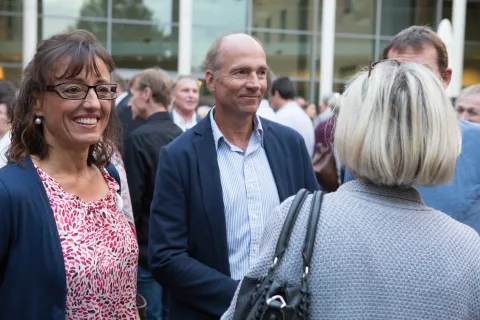Ein Mann und eine Frau unterhalten sich in einer Menschenmenge miteinander.