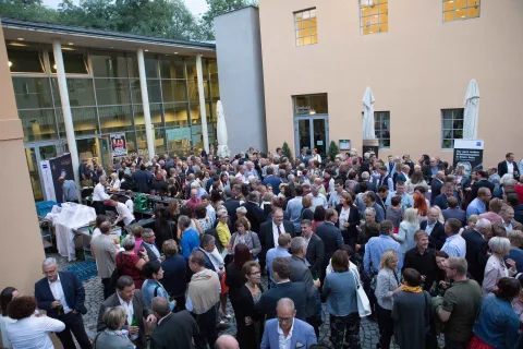 Eine große Gruppe von Menschen hat sich vor einem Gebäude versammelt