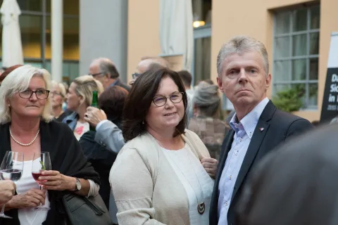Ein Mann und eine Frau stehen in einer Menschenmenge nebeneinander.