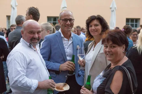 Eine Gruppe von Menschen steht in einer Menschenmenge nebeneinander.