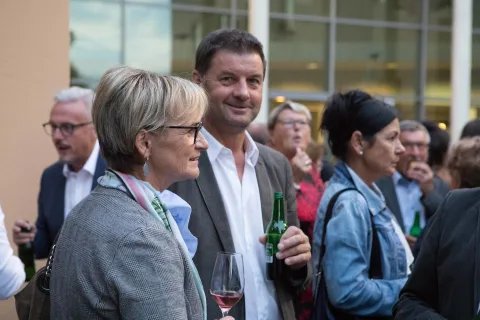 Ein Mann und eine Frau stehen in einer Menschenmenge nebeneinander.