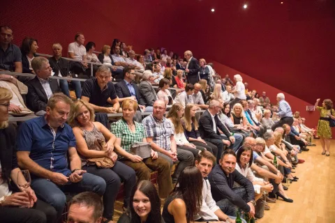 Eine große Gruppe von Menschen sitzt in einem Auditorium.