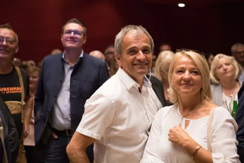 Ein Mann und eine Frau posieren vor einer Menschenmenge für ein Foto.