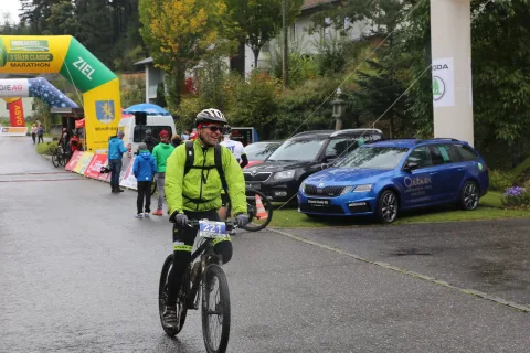 Ein Mountainbiker fährt im Regen durch den Zielbogen