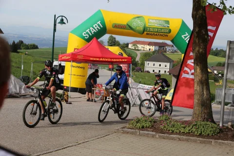 Fahrer sammeln sich unter dem Startbogen