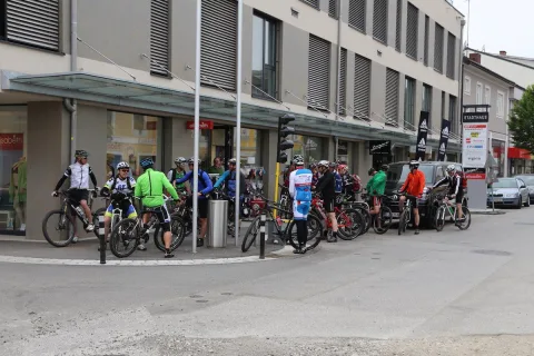 Radfahrer sammeln sich mit ihren Rädern vor dem Geschäft