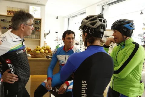 Radfahrer stehen im Geschäft beisammen und unterhalten sich nach der Ausfahrt