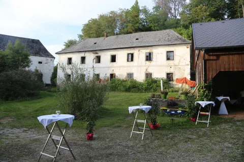 Ein großes Gebäude mit Tischen und Stühlen davor.