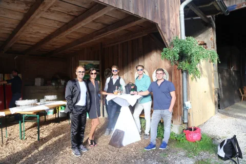 Eine Gruppe von Menschen steht vor einem Holzgebäude.