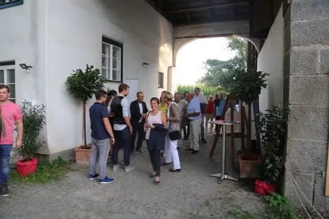 Eine Gruppe von Menschen steht vor einem Gebäude.