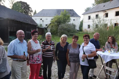 Eine Gruppe von Menschen steht vor einem großen weißen Gebäude.