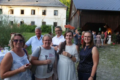 Eine Gruppe von Menschen posiert vor einem Gebäude für ein Foto.