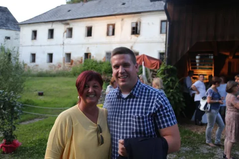 Ein Mann und eine Frau posieren vor einem Gebäude für ein Foto.