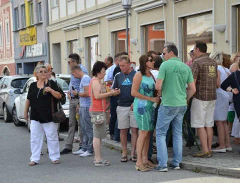 Gäste stehen in der Straße vor dem Geschäft
