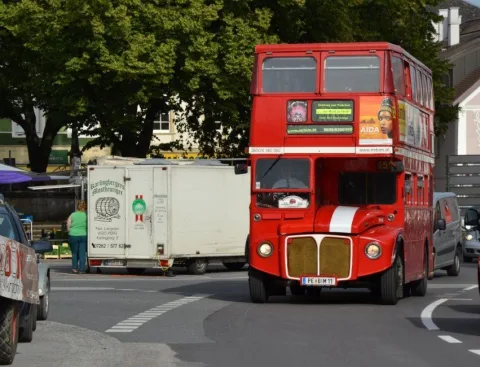 Ein roter Doppeldeckerbus fährt durch die Straße