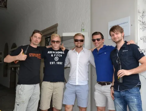 Fünf Gäste im Gruppenbild vor der Hauswand