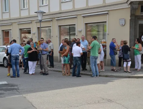 Blick die Straße entlang mit Besuchern und Fahrzeugen