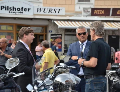Gäste zwischen Motorrädern vor den Geschäften