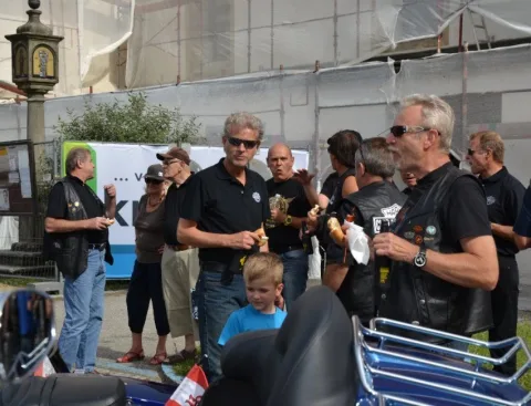 Gäste mit Getränken neben einem Motorrad