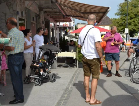 Besucher in der Straße unter einer Markise