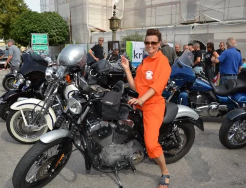 Eine Person in orangem Overall zwischen Motorrädern