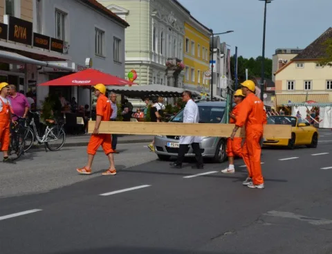 Zwei Helfer tragen ein Brett über die Straße