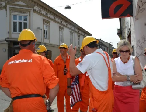 Helfer mit Bauhelmen und Gäste auf der Straße