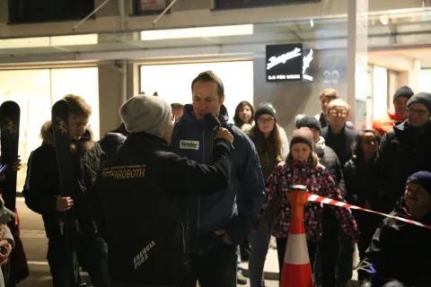 Ein Mann mit Mikrofon spricht mit Besuchern