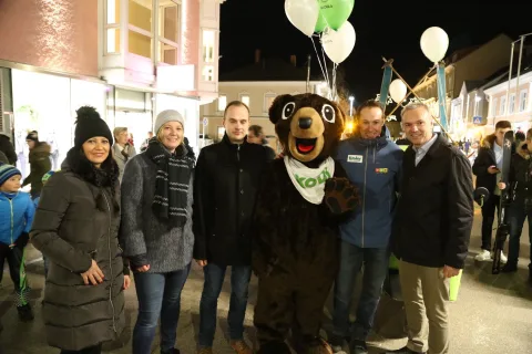 Fünf Personen mit einem Maskottchen im Bärenkostüm