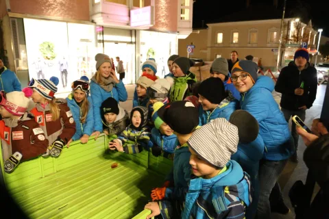 Kinder an einem Stand mit grüner Auflage