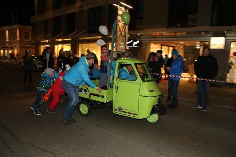 Ein Kind schiebt den Kleintransporter an