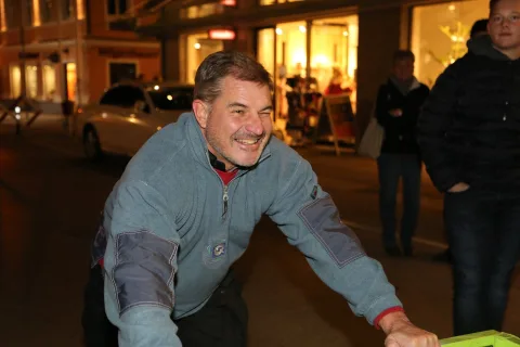 Ein Mann beugt sich lachend zur Kamera