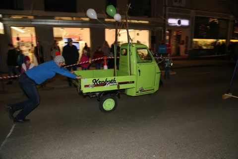 Eine Person schiebt den Kleintransporter an