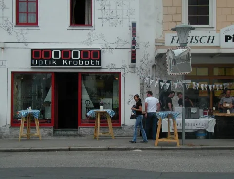 Die Hausfront mit Optik-Kroboth-Schriftzug und Wimpelketten