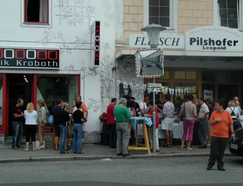 Blick die Straße entlang mit Gästen vor den Geschäften