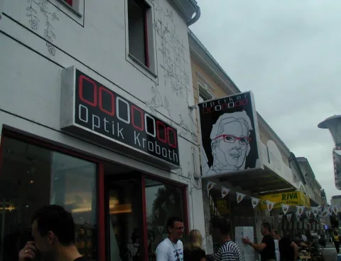 Die Hausfront mit Werbebild und Wimpelketten